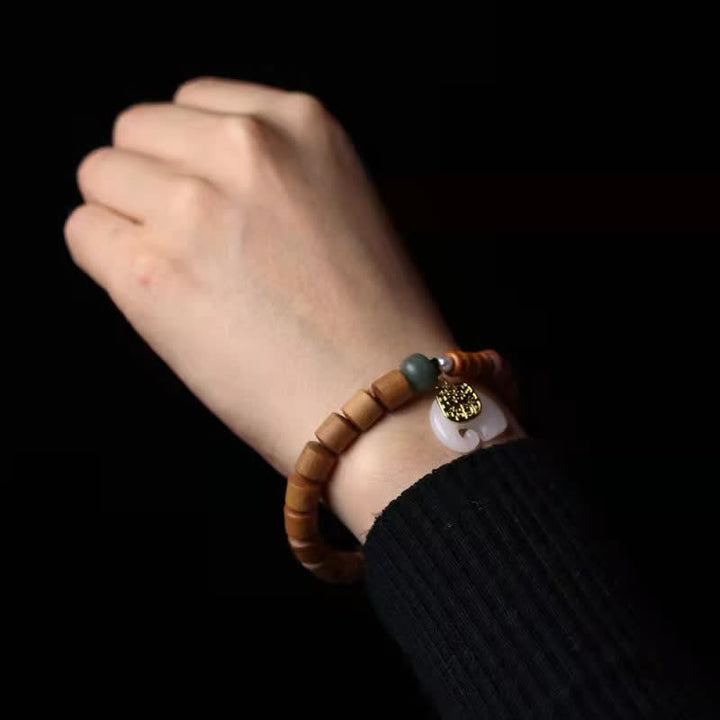 Sandelholz Armband mit Jade und Elefant Charm am Handgelenk getragen
