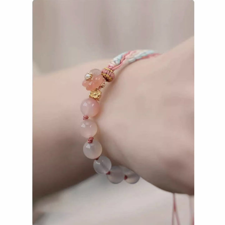 Armband Achat Pfirsichblüte am Handgelenk mit rosa Natursteinen und goldenen Perlen