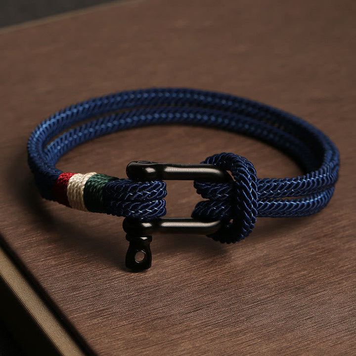 Marineblaues Seilarmband mit Edelstahlverschluss auf Holzoberfläche