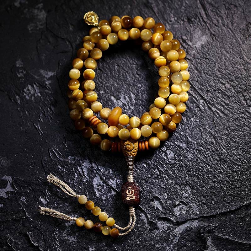 Mala Tigerauge Kupfer Perlenarmband mit Quaste auf schwarzem Stein
