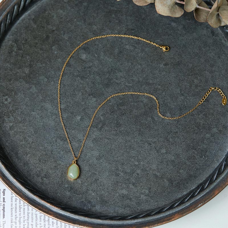Kette Aventurin Amethyst Rosenquarz – Segen – Bild 5 – Goldene Kette mit ovalem Aventurin Anhänger auf grauem Tuch