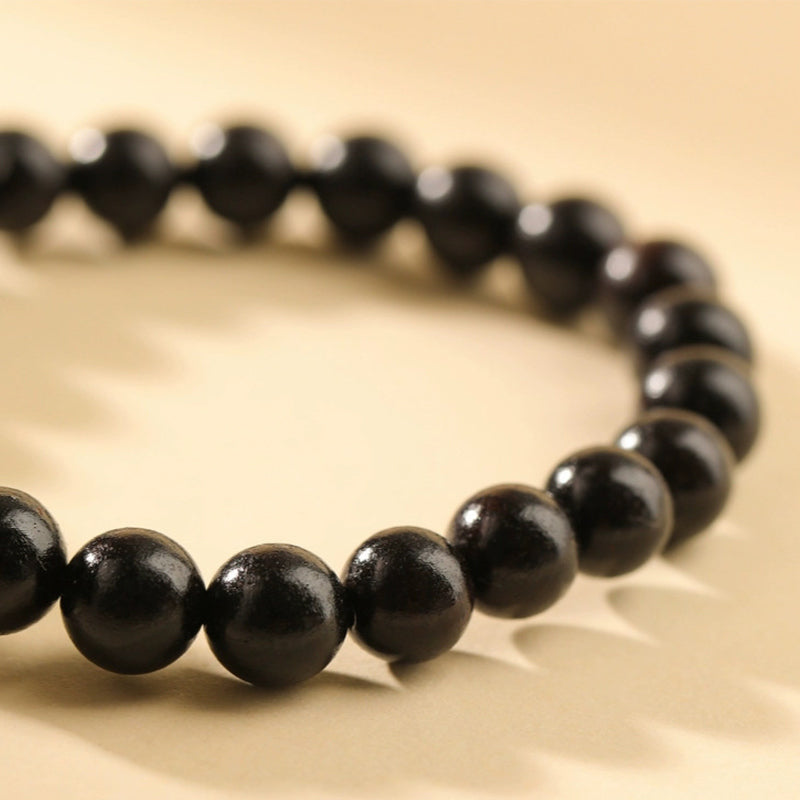 Schwarzes Ebenholz Armband mit glänzenden Perlen elastisch getragen