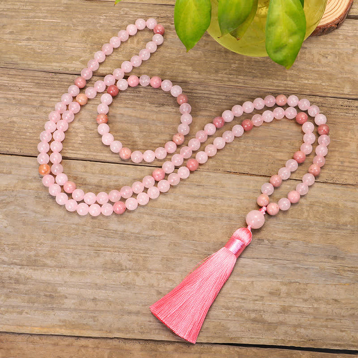 Rosenquarz Mala 108 Perlen Kristall mit rosa Quaste Holzuntergrund.