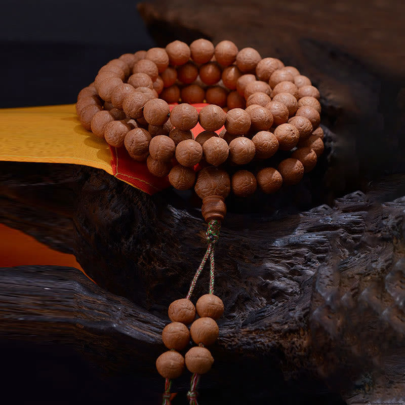 Mala Bodhi Armband aus Holzperlen auf Naturholz elegant präsentiert.