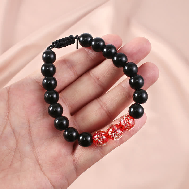 Armband Schwarzer Obsidian – Stärke mit roten Kristallperlen elegant.