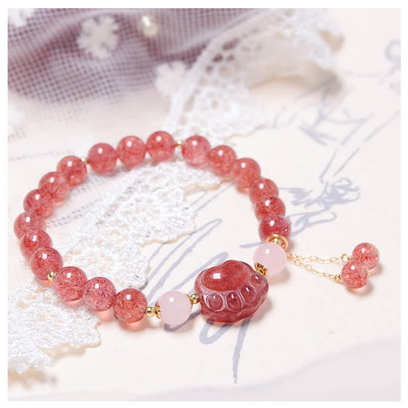 Erdbeerquarz Kristall Armband mit rosafarbenem Katzen-Anhänger elegant getragen