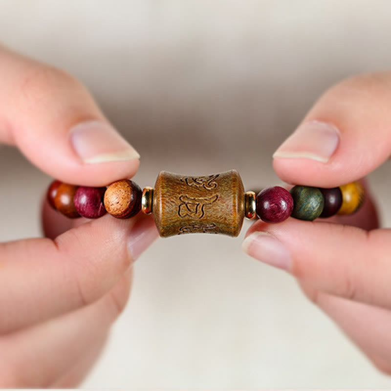 Sandelholz Om Mani Padme Hum Armband mit farbigen Perlen in Hand gezeigt.