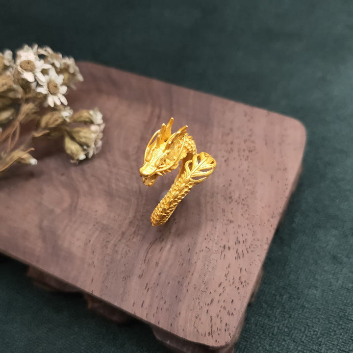 Goldener Drachen Ring Erfolg Stärke auf Holzpad mit Blüten