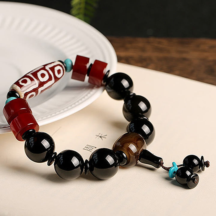 Armband Schwarzer Onyx mit roten und türkisen Perlen elegant präsentiert