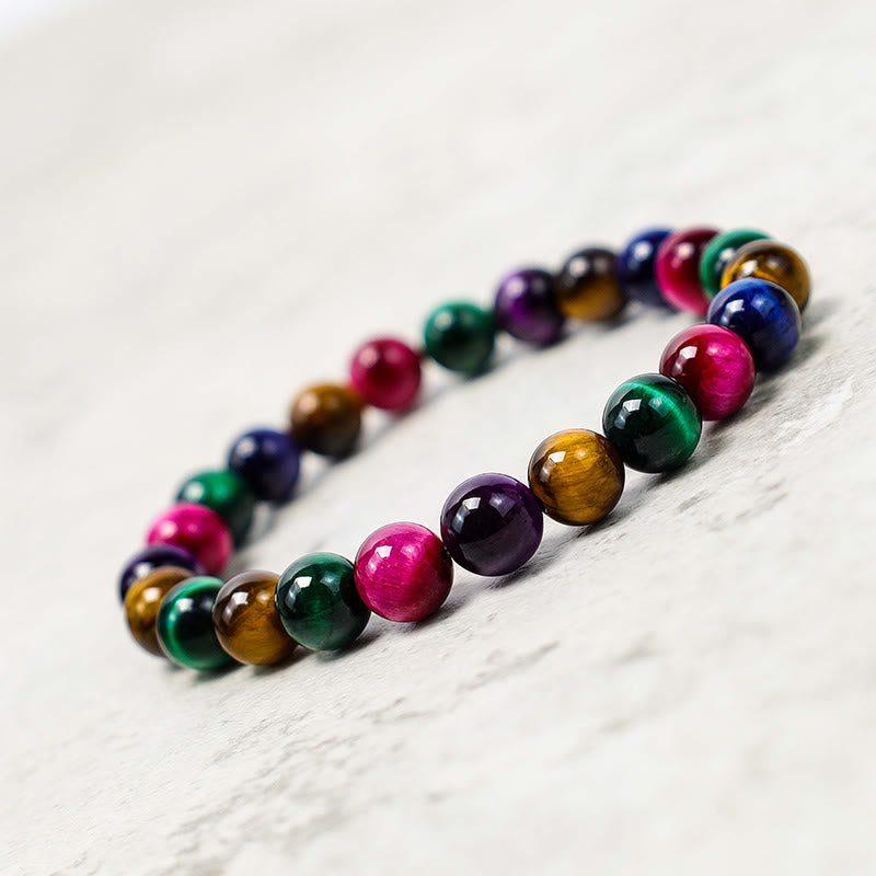 Armband Tigerauge – Mut mit bunten Natursteinen auf Marmor.