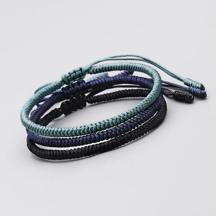 Drei geflochtene Tibetische Armbänder in Schwarz, Dunkelblau und Grün.