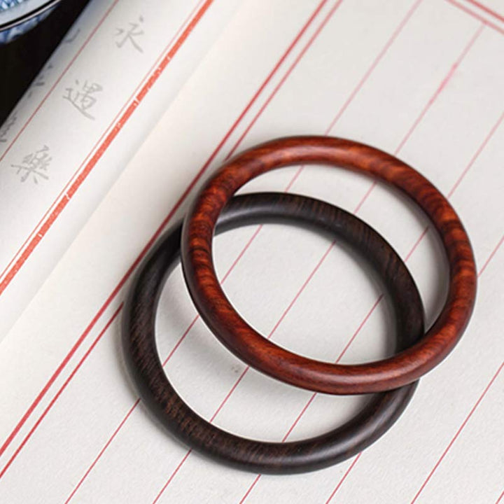 Zwei Sandelholz Armbänder auf Notizbuch Flat Lay braun schwarz Schutz