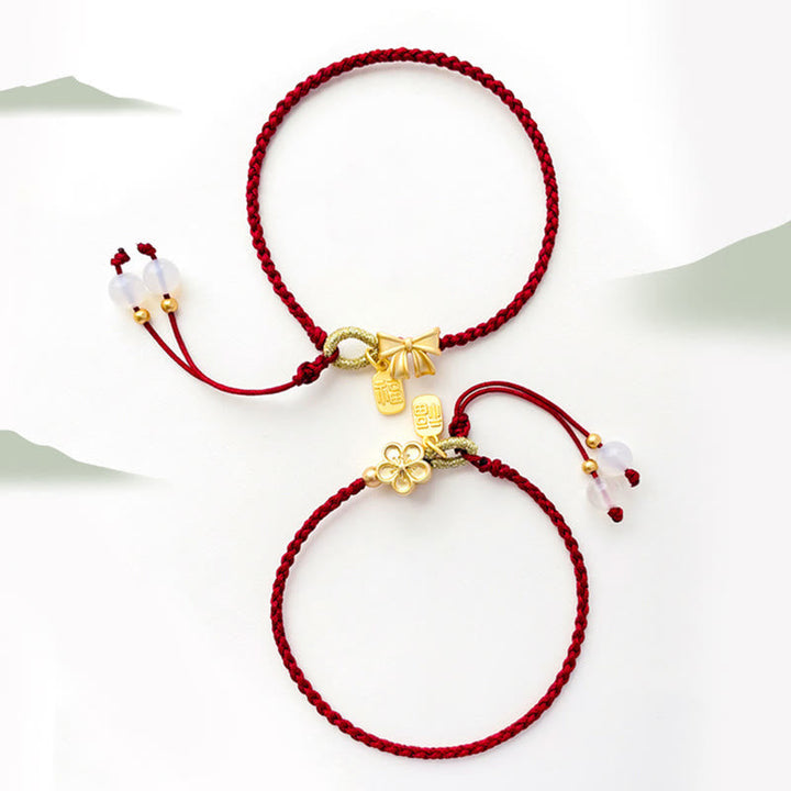 Rotes Armband Pfirsichblüte Glück Energie mit goldenen Charms elegant.