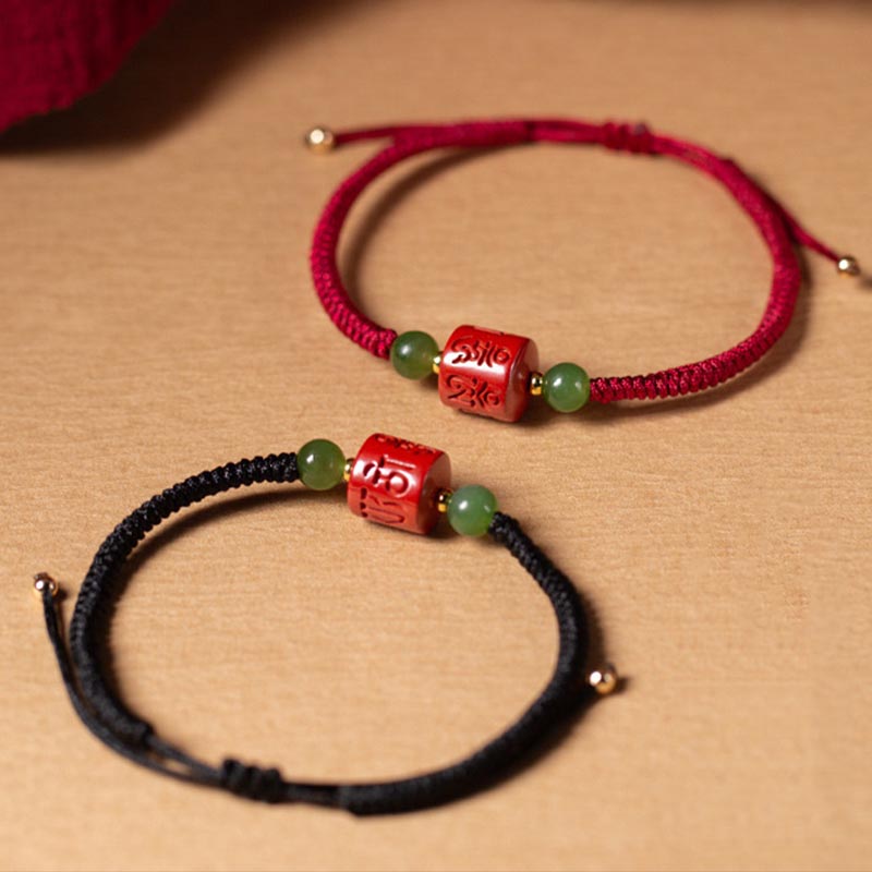 Rotes und schwarzes Armband mit grünen Steinen und roten Perlen.