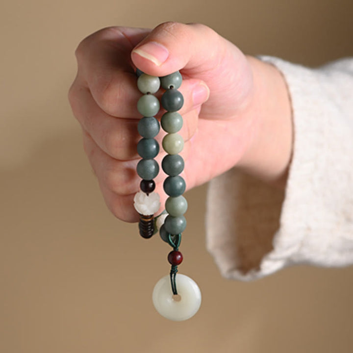 Bodhi Jade Lotus Armband Frieden mit Natursteinen in Hand gehalten.