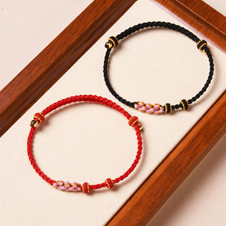 Rotes und schwarzes Armband Pfirsichblüte – Schutz mit Perlen.