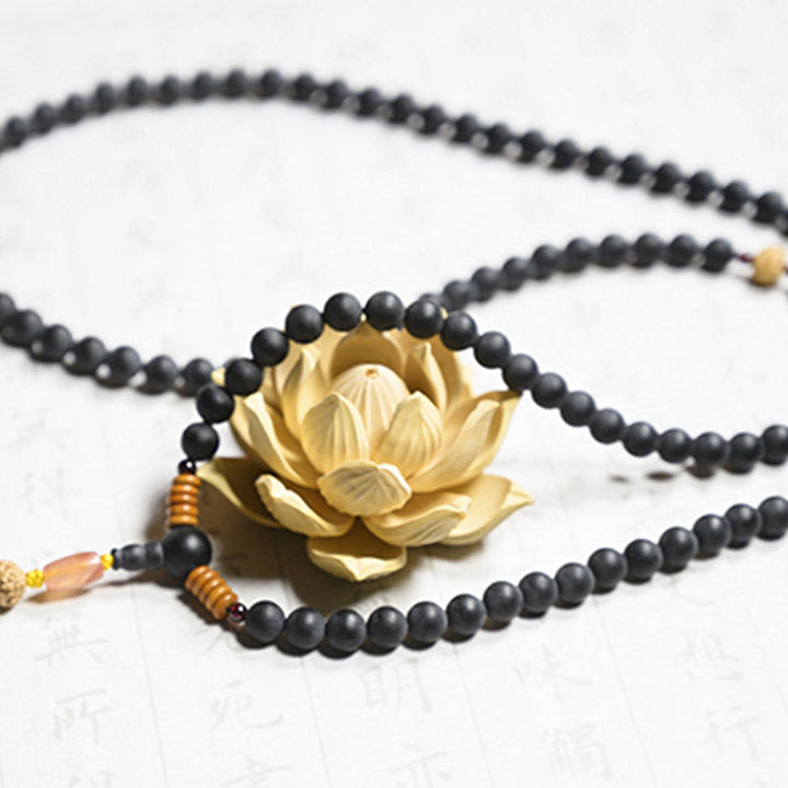 Goldene Lotus Mala mit schwarzen Perlen Halskette Flachlage Detail