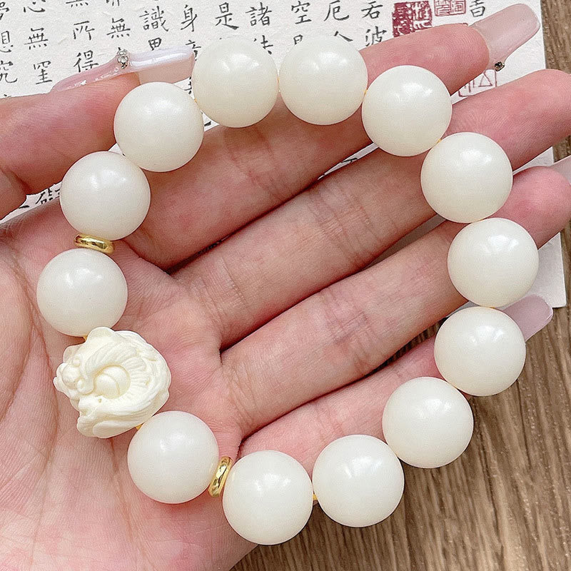 Weißes Jade Armband mit Bodhi Anhänger an Hand getragen