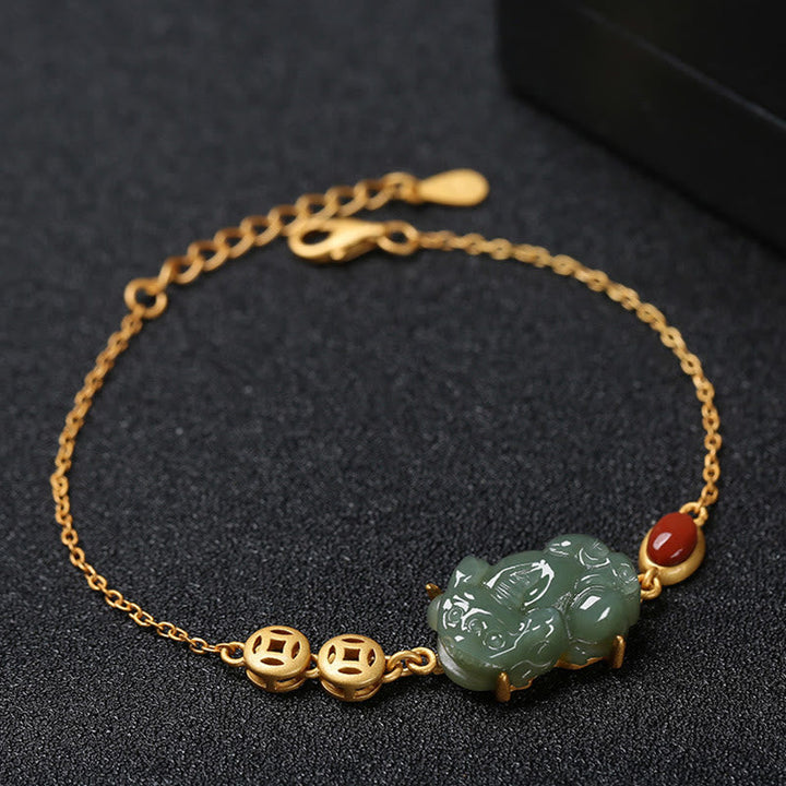 Elegantes Armband mit Jade Pixiu und rotem Achat auf dunklem Hintergrund.