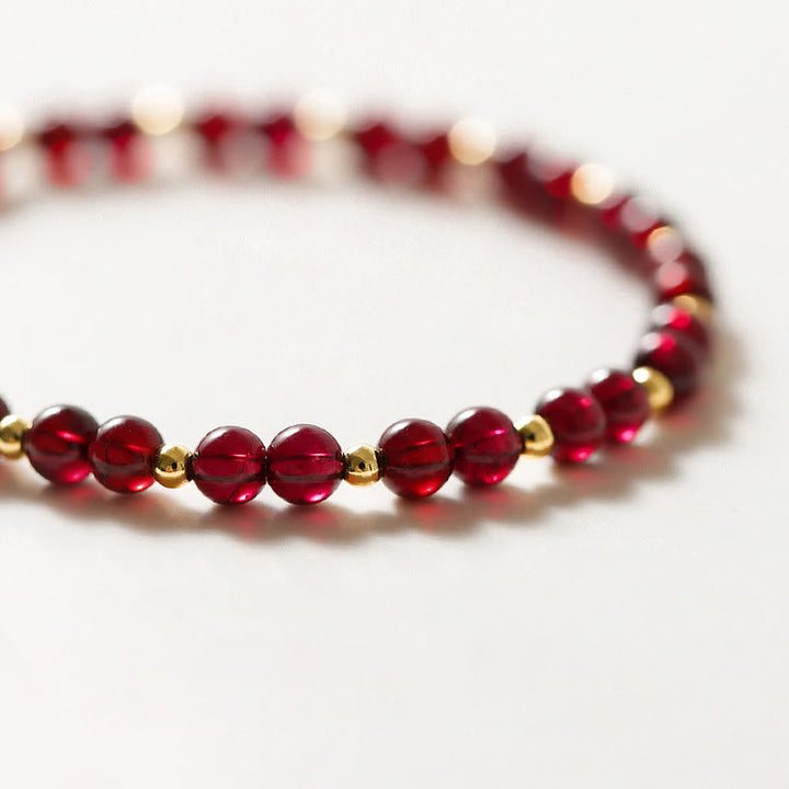Rotes Granat Armband mit Gold-Perlen auf weißem Hintergrund Detailansicht