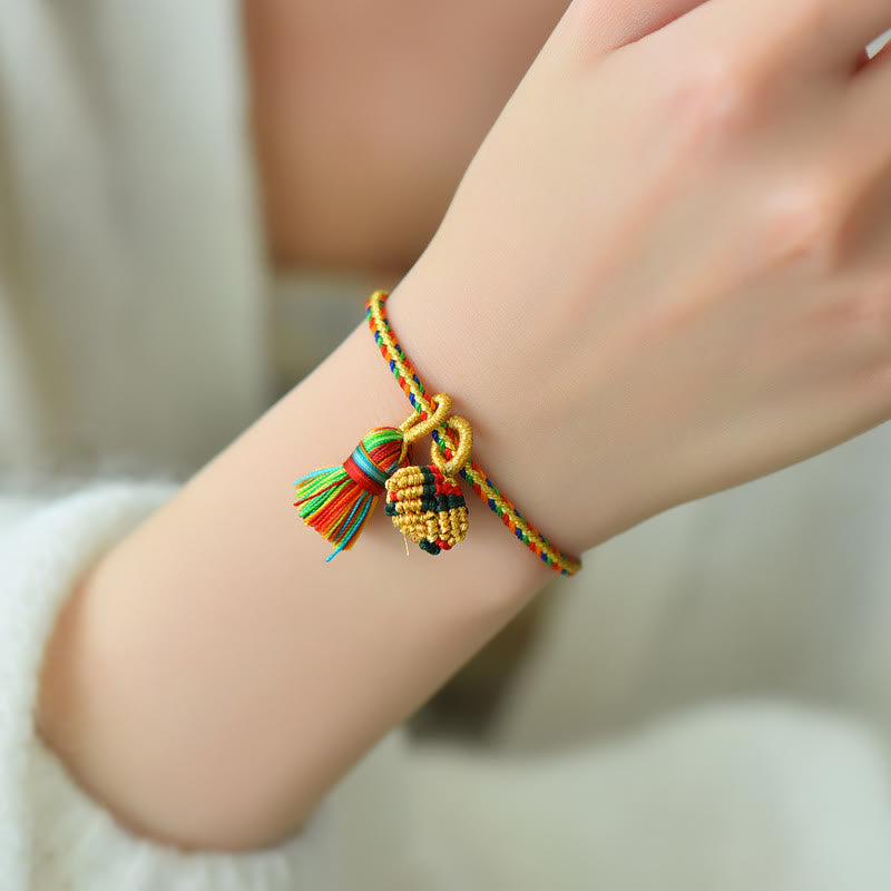 Buntes Armband mit Zongzi und goldenen Perlen am Handgelenk getragen.