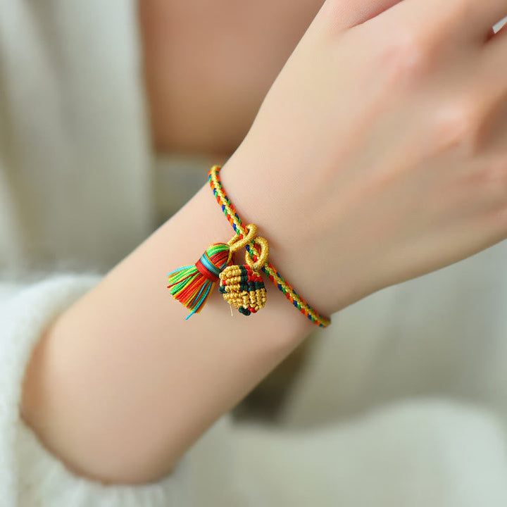 Buntes Armband mit Zongzi und goldenen Perlen am Handgelenk getragen.