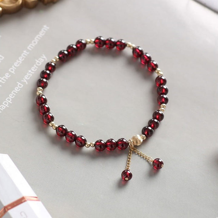 Armband Granat – Ruhe rote Perlen Goldperlen elastisch Flachlage