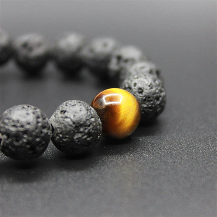 Tigerauge Armband mit goldener Kugel und schwarzen Lavastein Perlen Heilung.