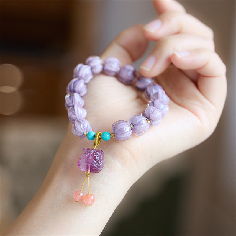 Armband Fluorit Lotus am Handgelenk mit lila Steinen und Anhänger