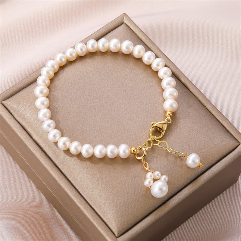 Elegantes Perlarmband mit goldenem Verschluss und Perlenanhänger.