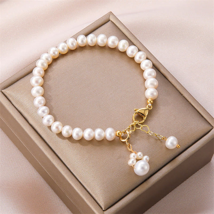 Elegantes Perlarmband mit goldenem Verschluss und Perlenanhänger.