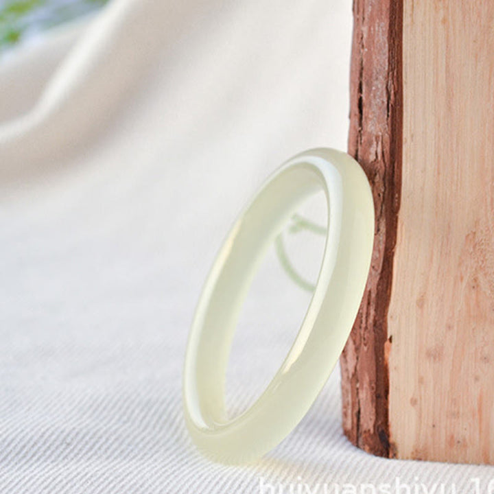 Jade Armband Fülle cremeweiß elegant an Holz angelehnt natürlich