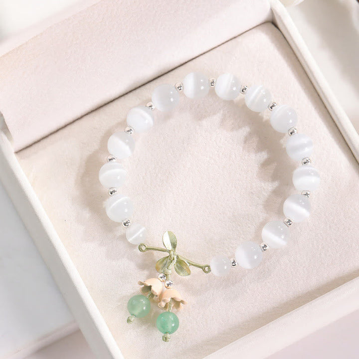 Weißes Perlen Armband mit grünem Aventurin und Katzen Charm Anhänger.