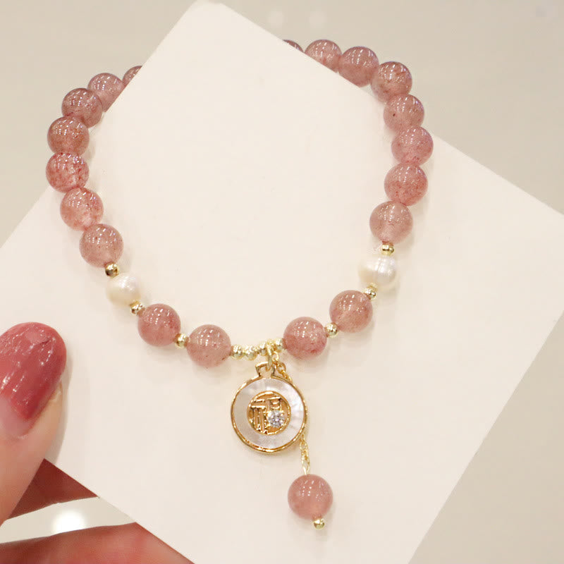Armband Erdbeerquarz Perle Fu-Zeichen elastisch mit goldenem Anhänger getragen