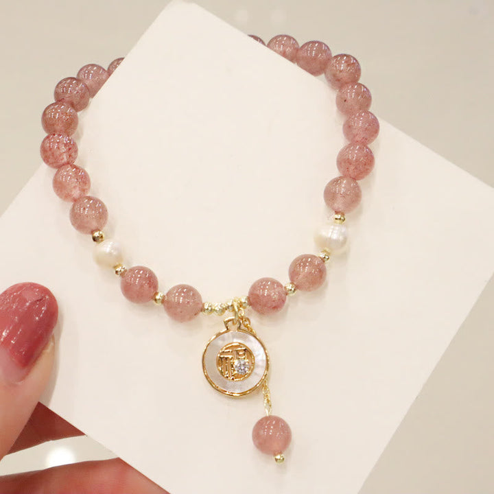 Armband Erdbeerquarz Perle Fu-Zeichen elastisch mit goldenem Anhänger getragen