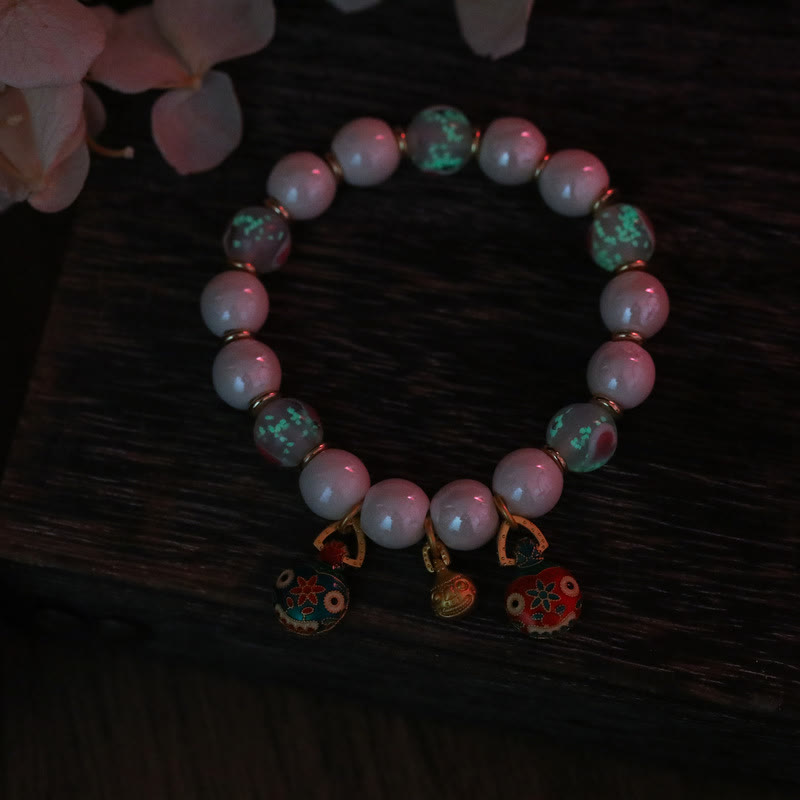 Rosenquarz Armband mit grünen Perlen und roten Charms elegant.