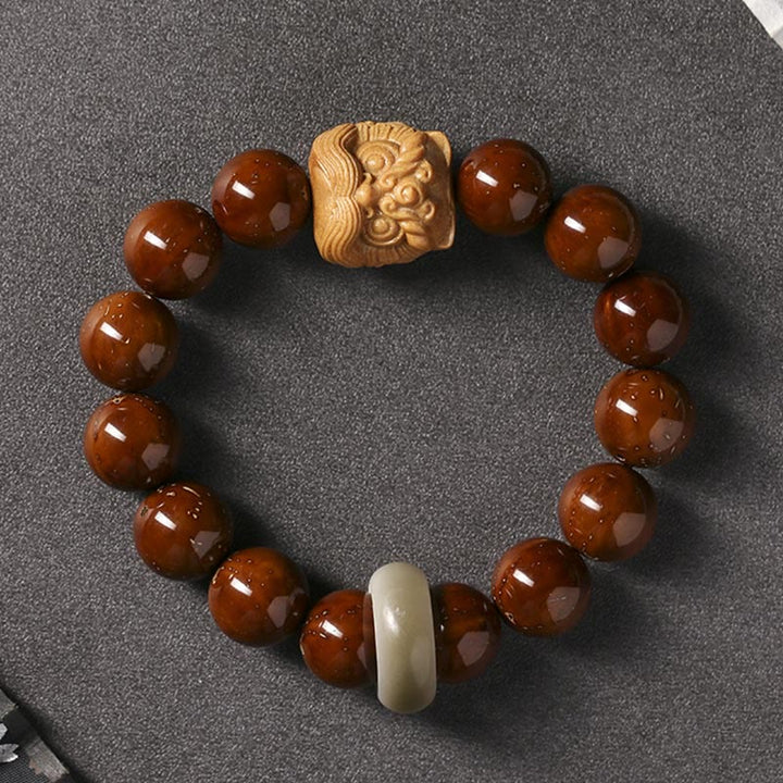 Armband mit braunen Perlen, Bodhi Samen und Holzschnitzerei Löwe.