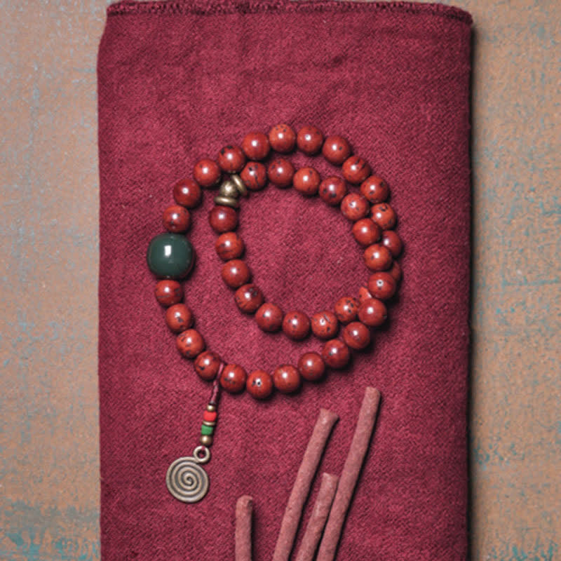 Rotes Perlen Armband mit Jade und Spiralanhänger displayed