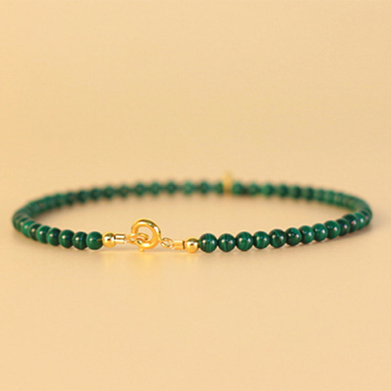 Grünes Malachit Armband mit Goldfarbener Schließe elegant präsentiert.