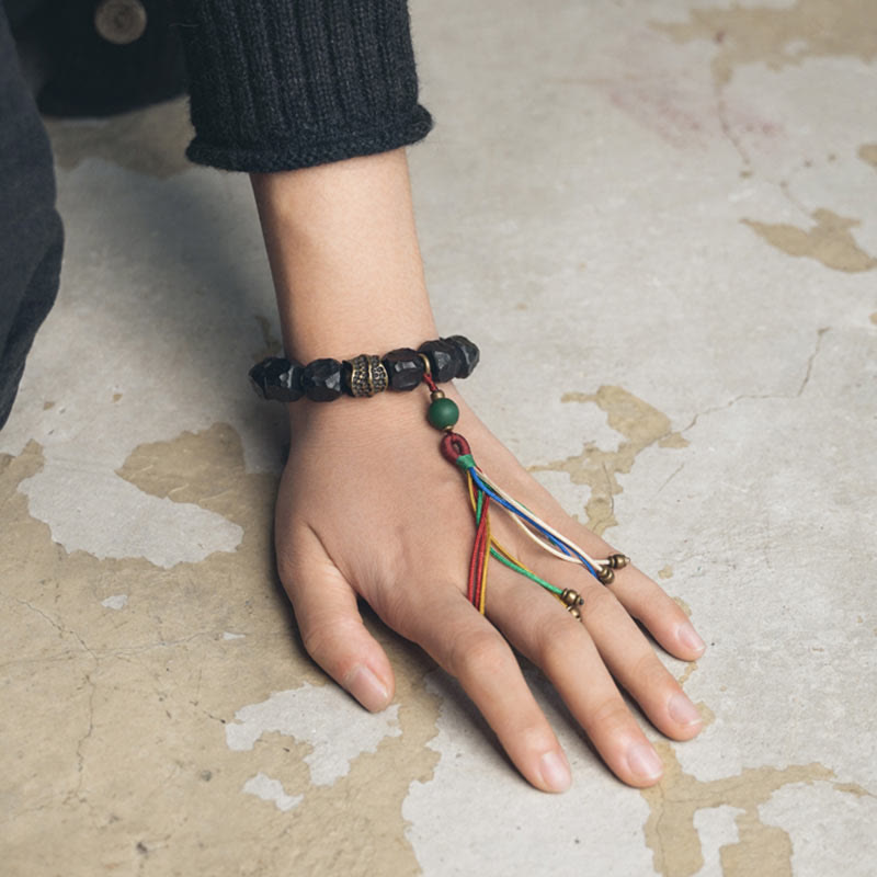 Mala Kupfer Ebenholz Frieden Armband Hand mit buntem Anhänger getragen