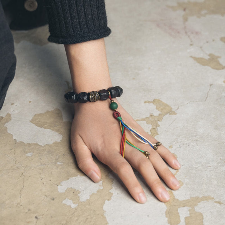 Mala Kupfer Ebenholz Frieden Armband Hand mit buntem Anhänger getragen