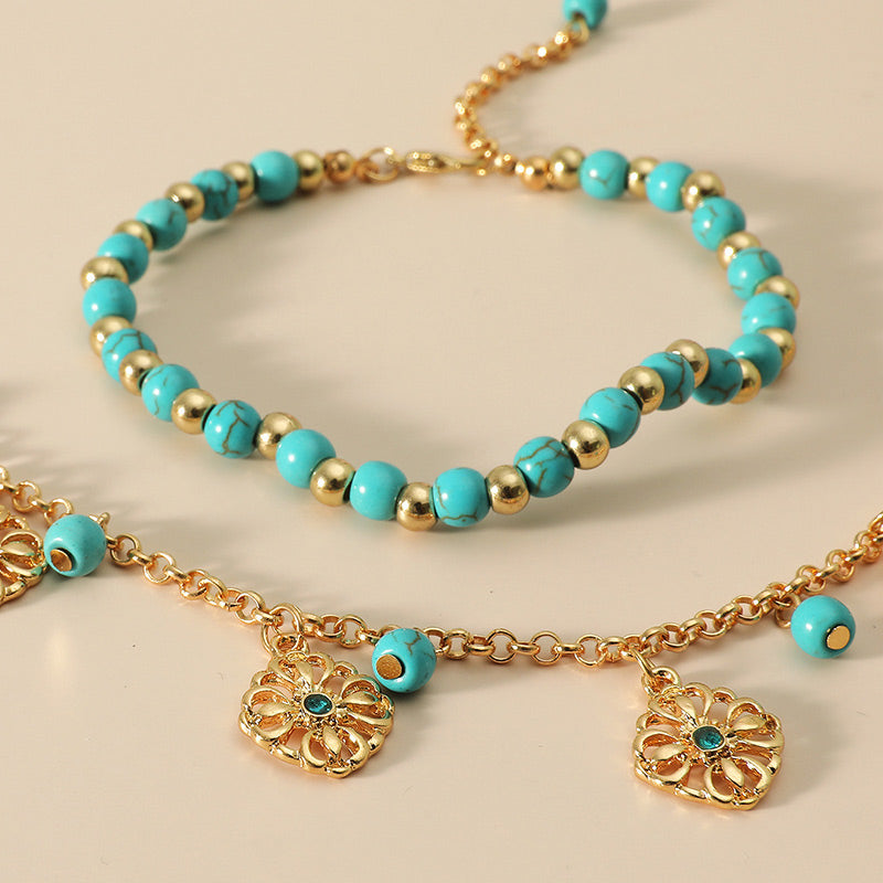 Armband Türkis – Schutz mit goldenen Perlen und Blütenanhängern.