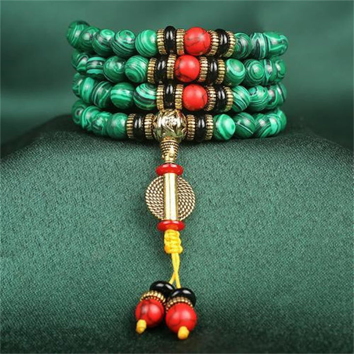 Mala Malachit 108 Perlen Armband grüne Steine goldene Metall Details auf Stoff
