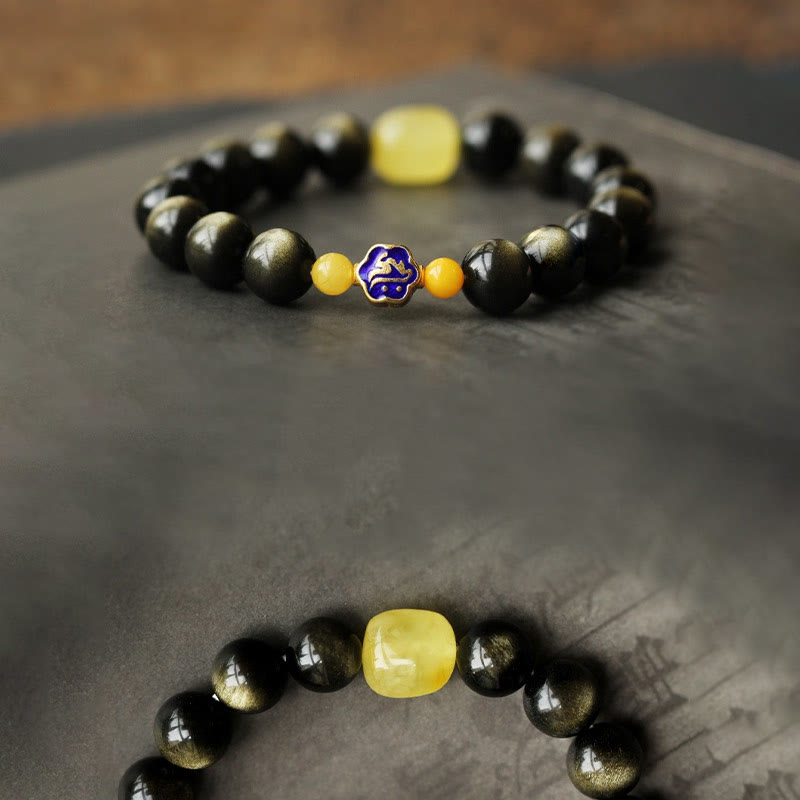 Schwarzes Obsidian Armband mit gelbem Stein und blauem Charm elegant.