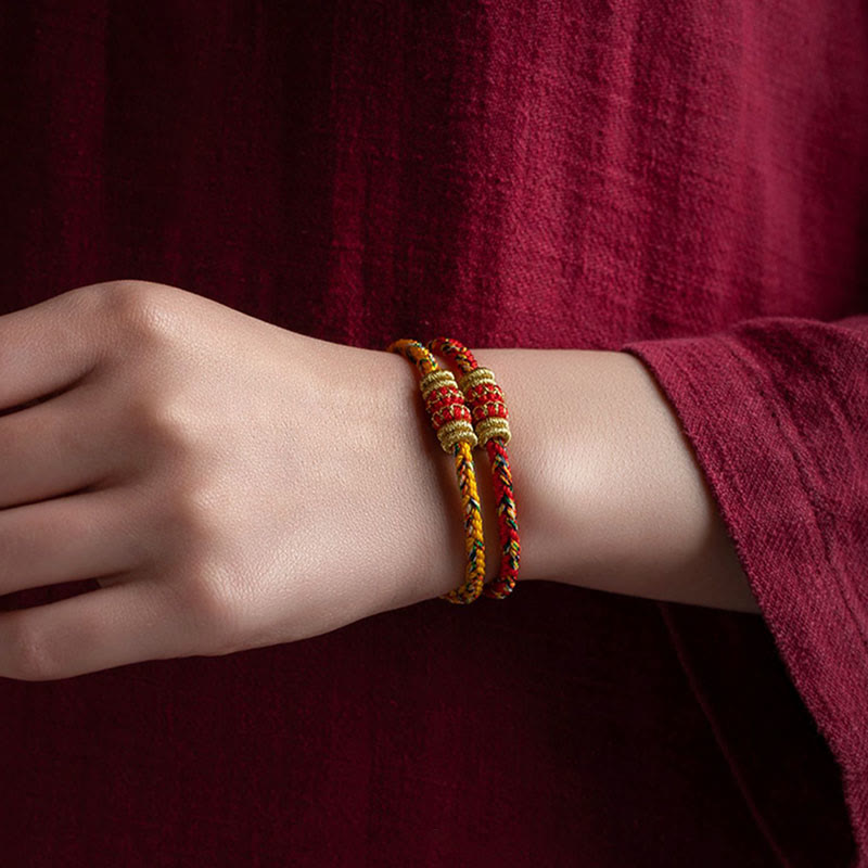 Armband Schutzbuddha Glück Stärke rot gold geflochten Handgelenk getragen