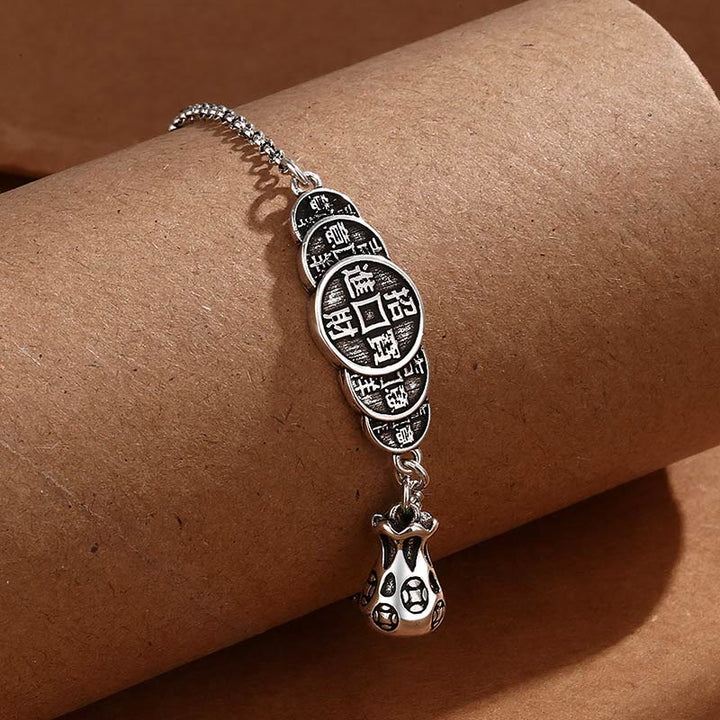 Silbernes Armband mit chinesischen Münzen Anhängern am Handgelenk getragen.