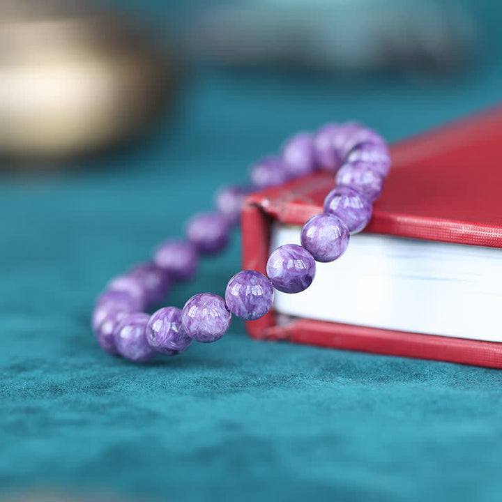 Amethyst Kristall Armband lila Perlen auf türkisem Hintergrund elegant