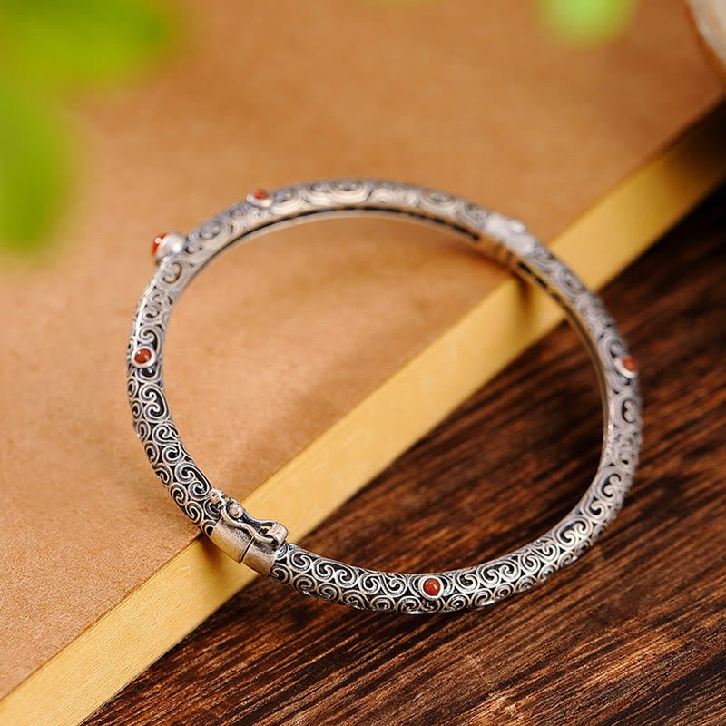 Silbernes Armband mit rotem Achat und ornamentalem Muster elegant.