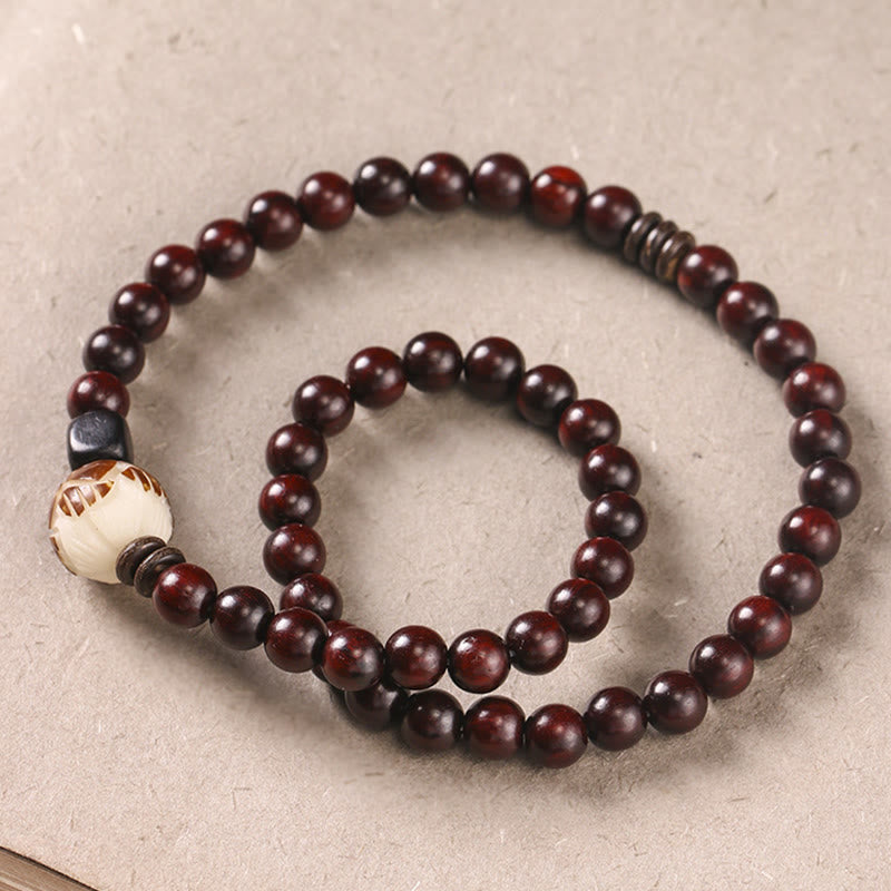 Sandelholz Bodhi Lotus Armband mit dunkelroten Holzperlen elastisch getragen.