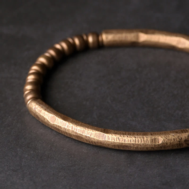 Kupfer Armband mit spiraliger Wicklung auf dunklem Hintergrund elegant.